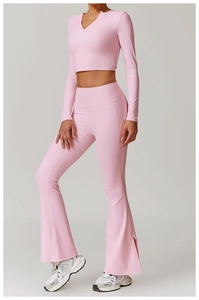 Detail of pink flare yoga pants with side slit and V-neck long sleeve cropped sports top