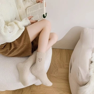 Detailed view of plush cream faux mink socks featuring a cute brown heart embroidery