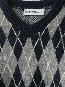 Detailed view of V-neck argyle knit sweater neckline with soft blue and grey patterns