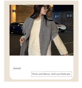 Detail of grey mohair knit shawl featuring thick texture and long decorative fringes