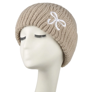 Bonnet en grosse maille beige avec broderie nœud blanc sur tête mannequin