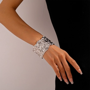Detail of silver textured wide cuff bracelet with artistic metallic folds on model