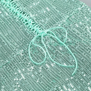 Close-up of mint green sequins and intricate cross-tie lacing on a formal evening gown