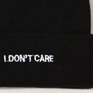 Black knit beanie with I DON'T CARE embroidery featuring a cuffed brim design