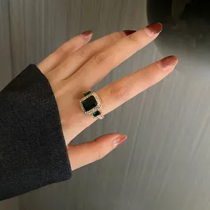 Macro detail of retro emerald ring with gold metal setting and micro-pave crystals
