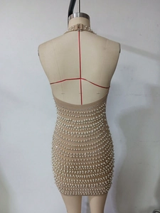 Detail of champagne bodycon dress with horizontal rows of white pearls and rhinestones