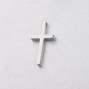 Polished silver stainless steel cross pendant with top hanging hole on grey surface