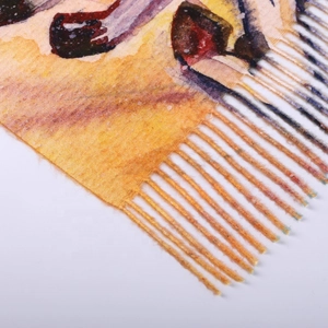 Detailed macro view of vibrant yellow and orange patterned scarf with soft fringe edges