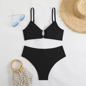 Flat lay of a sexy black two-piece bikini with V-neck top and high waist bottom set