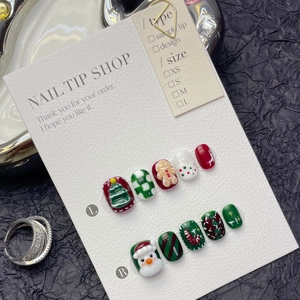 Detail of Christmas press-on nails featuring 3D gingerbread man and reindeer designs