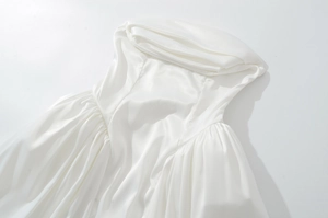Detalle de tela de satén blanco con elegante escote plisado y textura de seda