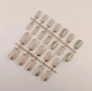 Close-up of 24pcs round press-on nails with nude pink base and gold glitter gradient