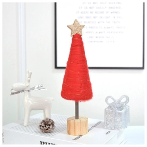 Detail of red felt Christmas tree with gold star topper and round wooden base decor