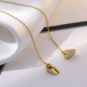 Gold plated 18K heart paperclip necklace with magnetic heart pendant on silk background