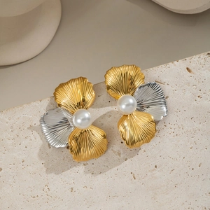 Close-up of elegant two-tone shell earrings with pearl inlay on stone background