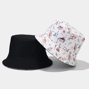 Detail view of double-sided bucket hats in solid black and colorful Australian animal print