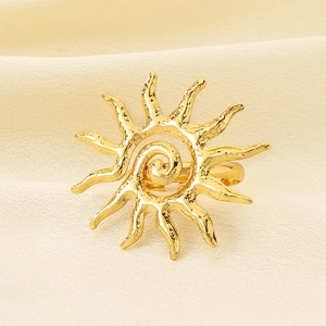 Detailed macro view of the golden solar spiral stainless steel ring on beige textured fabric