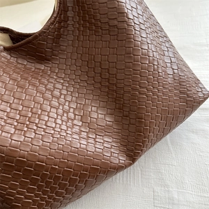 Brown woven leather shoulder bag with large capacity for women in a vintage fashion style