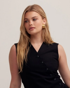 Detail of twisted 18K gold-plated striped fan earrings paired with a black V-neck vest