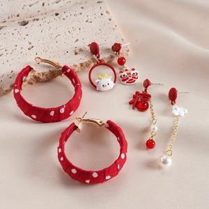 Detail of red fabric hoop earrings with Fu character and lion dance charms