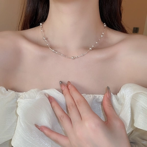 Detailed view of delicate layered pearl necklace on collarbone with elegant aesthetic