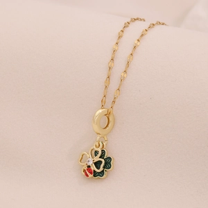 Gold clover necklace with green enamel pendant and a red ladybug accent and diamond