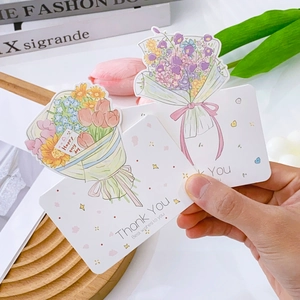 Nahaufnahme von Blumenstrauß-Grußkarten mit den Texten „Thank You“ und „Best wishes“.
