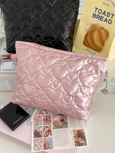 Detail of heart quilted cosmetic bags with pearl pendants and silky pearl finish