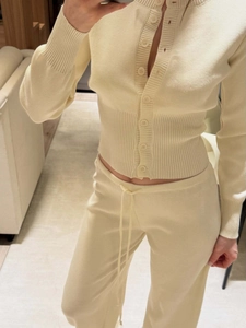 Elegant cream knit cardigan and drawstring wide-leg pants lounge set shown in a cozy room