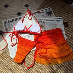 Detailed flat lay of three-piece gradient orange bikini set with wave knit texture