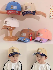 Detail of baby baseball cap with embroidered bear patch and contrasting color panels
