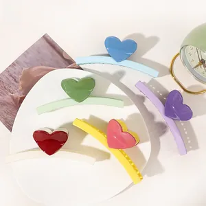 Close-up of heart-shaped hair claw clips in various colors like sky blue and green