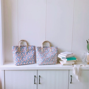Borsa tote floreale in cotone con manici in pelle in un ambiente domestico accogliente