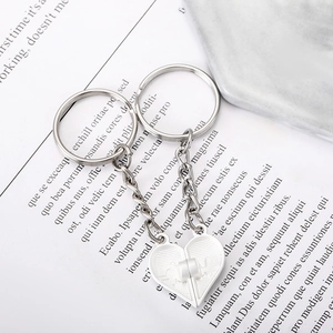 Magnetic silver heart couple keychain with EKG heartbeat pattern on marble surface