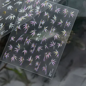 Macro shot of metallic bamboo leaf nail stickers with pink and white laser finish