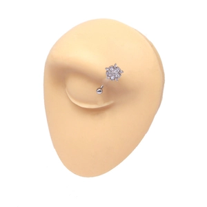 Detailed view of silver flower eyebrow piercing with white zircons on a skin-toned model