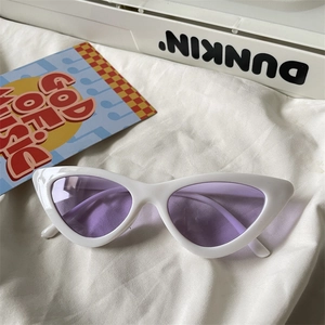 Detail of retro cat-eye sunglasses with white glossy frame and lilac purple lenses