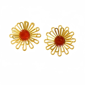 Elegant gold hollow flower earrings with red-orange center stone on white background