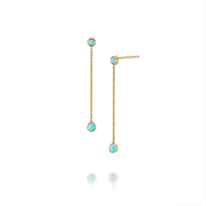 Detail view of gold tassel earrings with round turquoise stones on white background