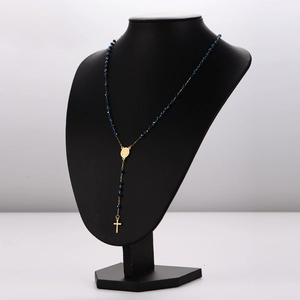 Vintage stainless steel oval bead necklace with golden cross pendant on mannequin