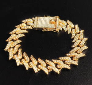 Close-up of golden iced-out Cuban link chain with diamonds and box clasp on black background