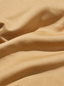 Gros plan sur le tissu en maille de couleur camel avec texture douce et détails fins