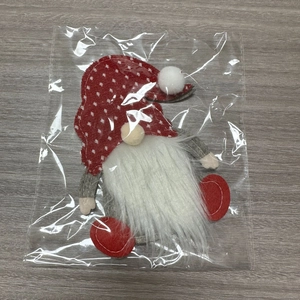 Close-up of plush Christmas gnome cutlery holders in red and white festive packaging