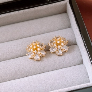 Detailed macro of 14k gold-plated flower stud earrings with clear zircon stones