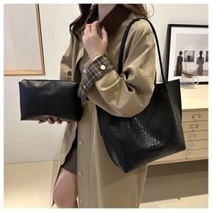 Detail of black woven texture tote bag and matching small pouch in minimalist style