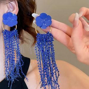 Detail of Klein blue floral earrings with long beaded tassels on model's ear