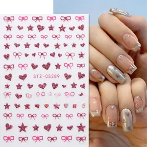 Detail of pink glitter nail stickers featuring bow, heart, and star designs with application