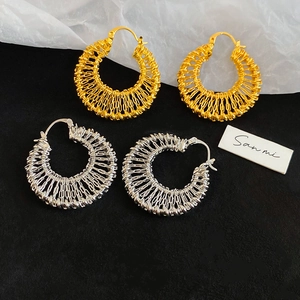Detail shot of 18k gold and silver hollow woven hoop earrings with intricate mesh texture
