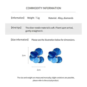 Détail montrant les dimensions des boucles d'oreilles fleurs vintage émaillées bleues