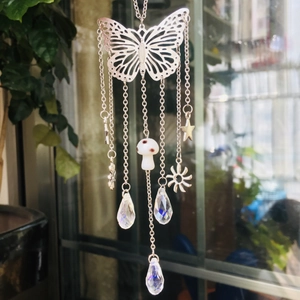Detail of silver butterfly suncatcher with mushroom, star, and crystal prism pendants